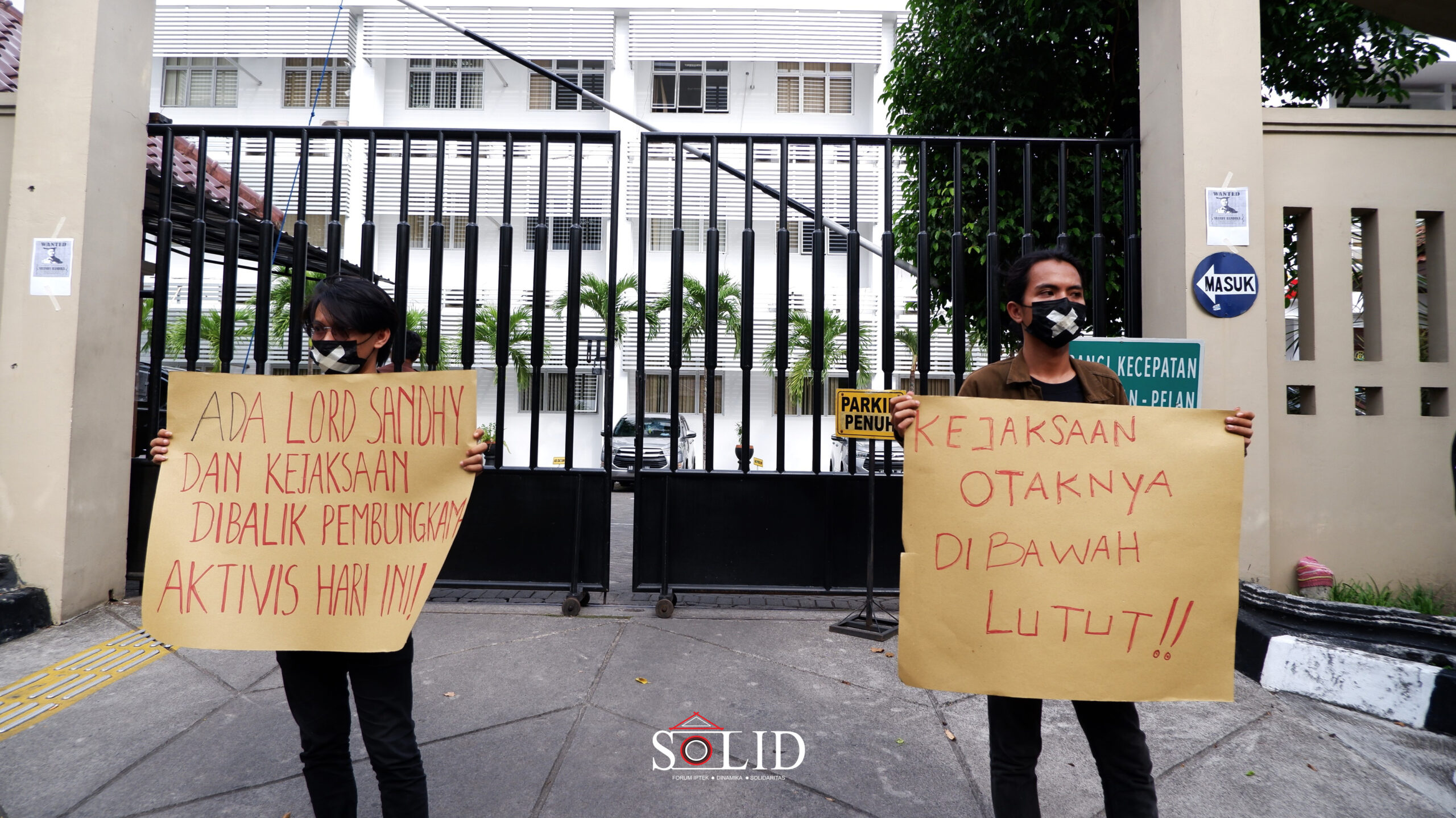 Massa Aksi berdiri di depan pagar kantor Kejaksaan DIY dengan membawa selebaran sebagai bentuk protes terhadap kejaksaan.